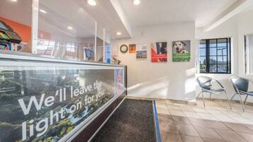 A reception area with a glass partition, a clock, and a window with a view.