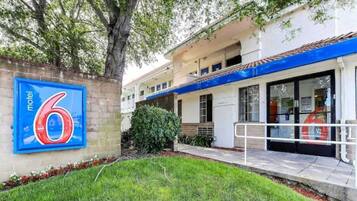 A motel with a large blue sign displaying the number 6.