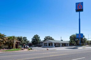 A motel with a prominent '6' sign, a single-story building, and a parking lot. - 2 Full Beds | Kingman, AZ (Kingman)