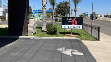A hotel entrance with a sign indicating 'studio 6 suites' and an arrow pointing left for the entrance.