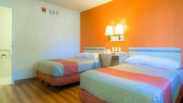 Ein Hotelzimmer mit zwei Betten, einem Schreibtisch und einem Stuhl.