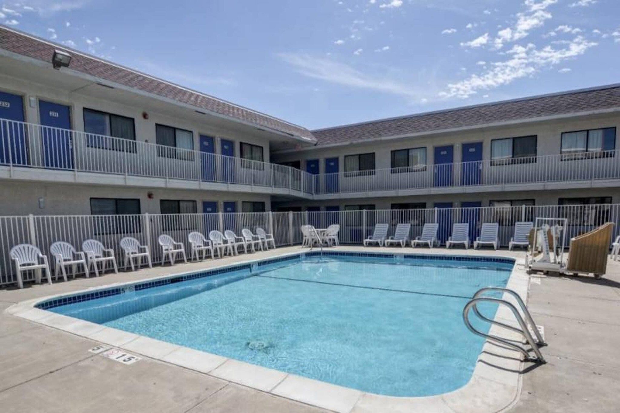 A pool area with lounge chairs and a pool.