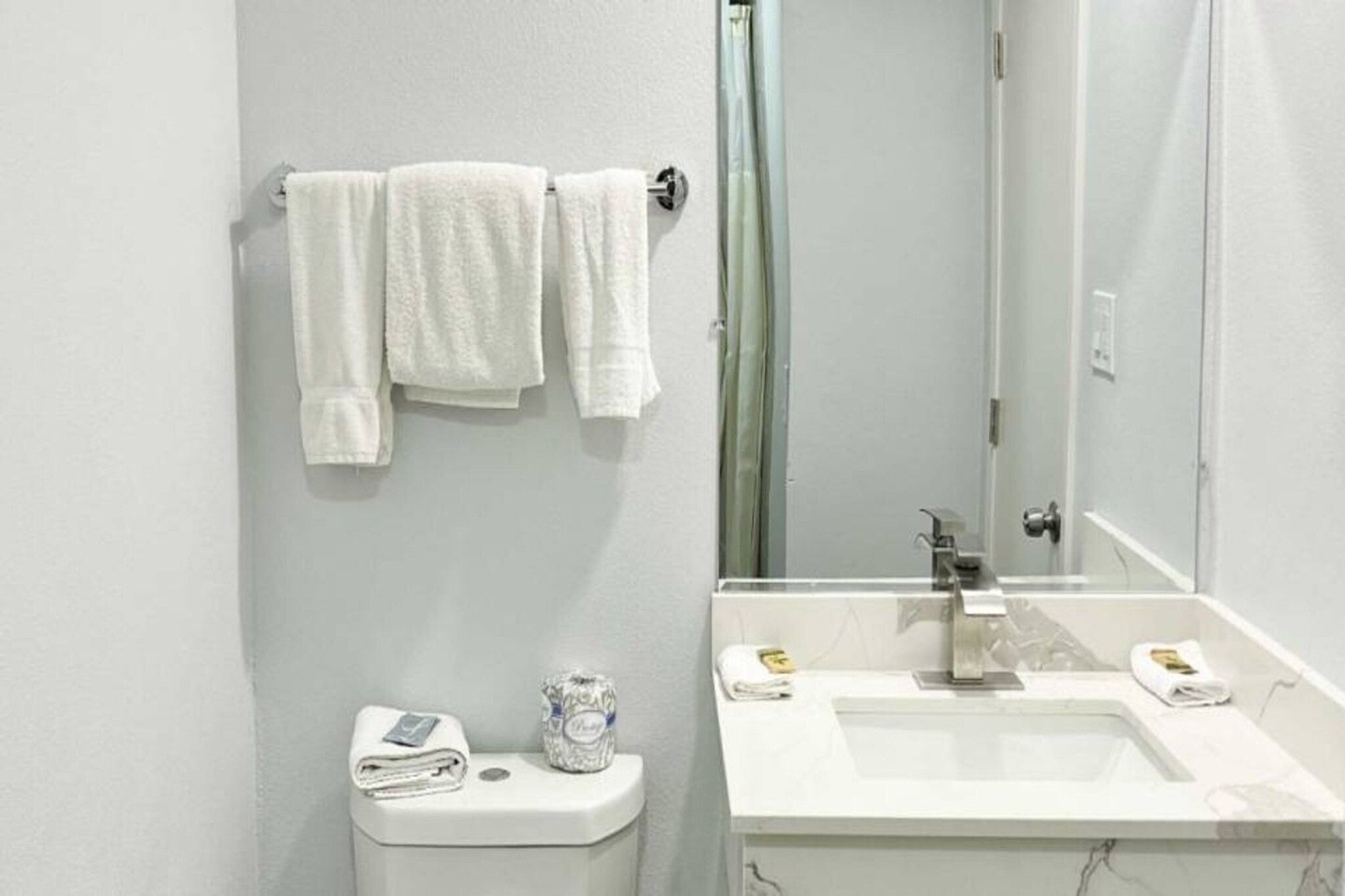 Une salle de bain avec des toilettes, un lavabo et un miroir.