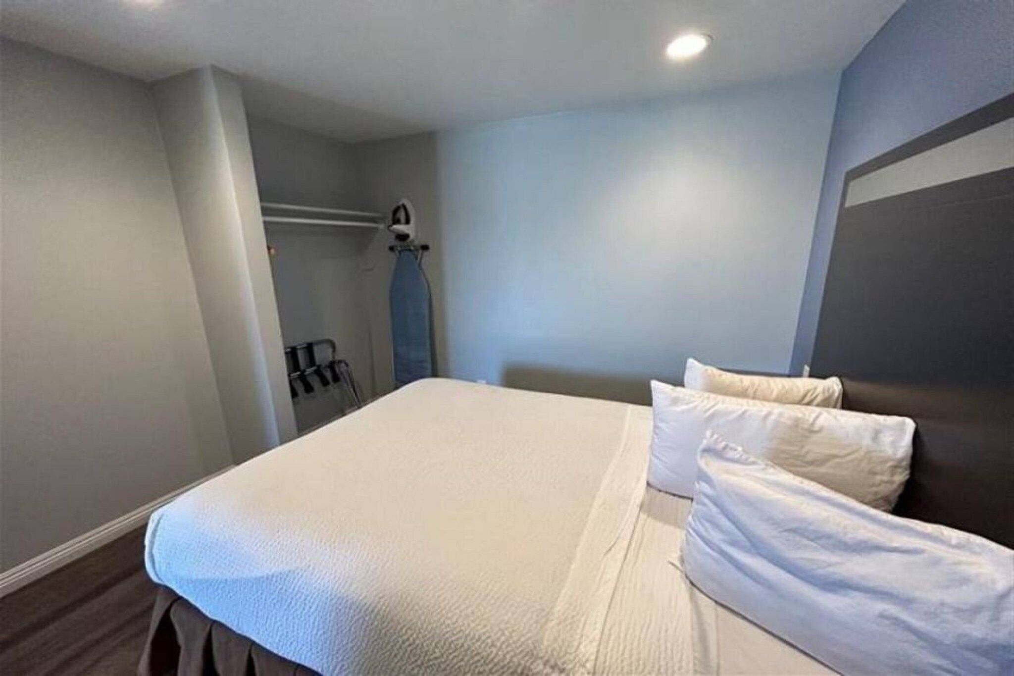 Een hotelkamer met een bed, een kledingkast en een spiegel.