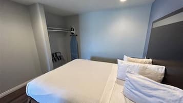 Een hotelkamer met een bed, een kledingkast en een spiegel.