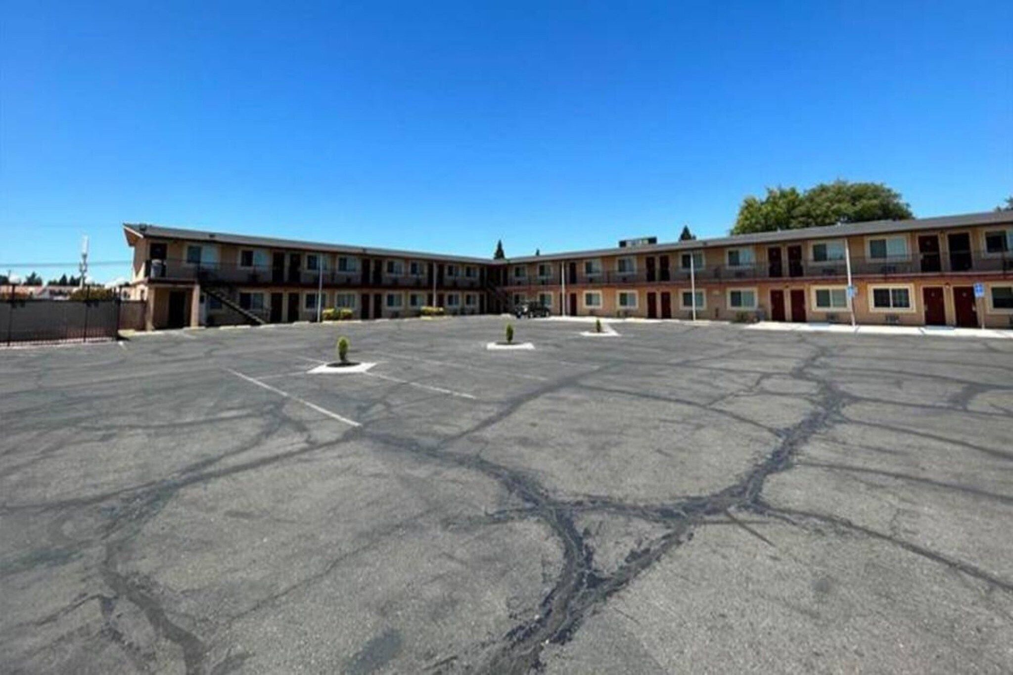 A large parking lot with a row of multi-story buildings in the background.