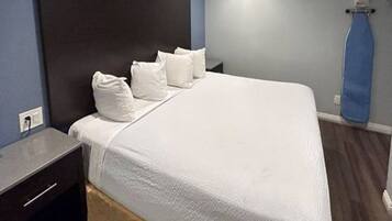 A hotel room with a bed, a nightstand, and a blue curtain.