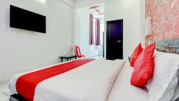 Habitación de hotel moderna con una cama grande, un televisor de pantalla plana en la pared y vistas al pasillo.