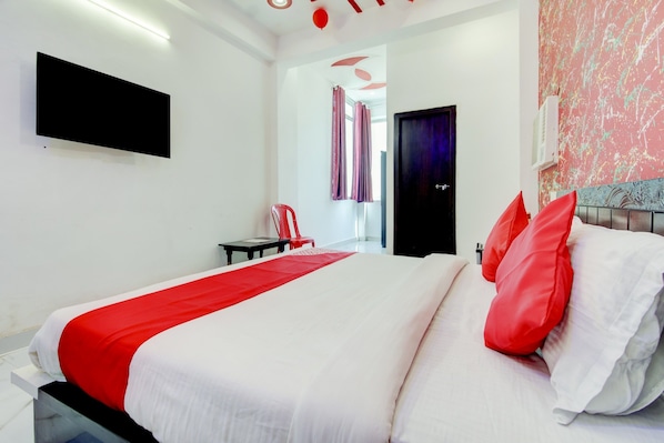 Habitación de hotel moderna con una cama grande, un televisor de pantalla plana en la pared y vistas al pasillo.