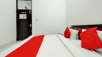 Habitación de hotel con cama, puerta y enchufe.