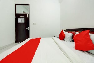 Habitación de hotel con cama, puerta y enchufe.