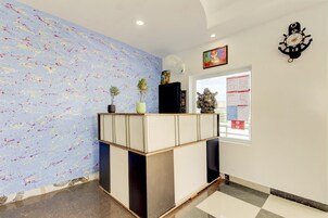 Un área de recepción de diseño moderno, con un mostrador, una pared con textura y un reloj en la pared.