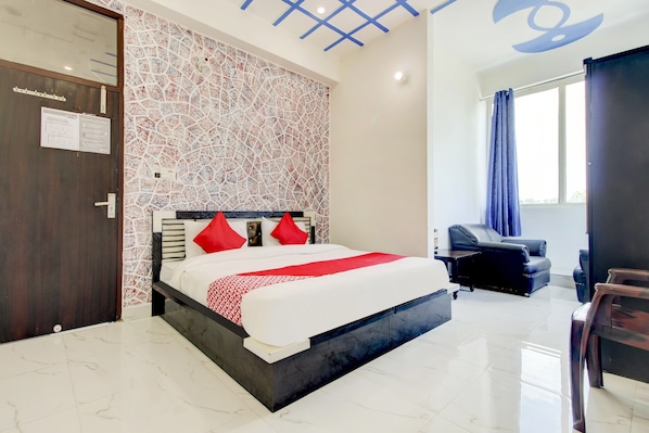A modern hotel room with a large bed, a desk, and a chair.