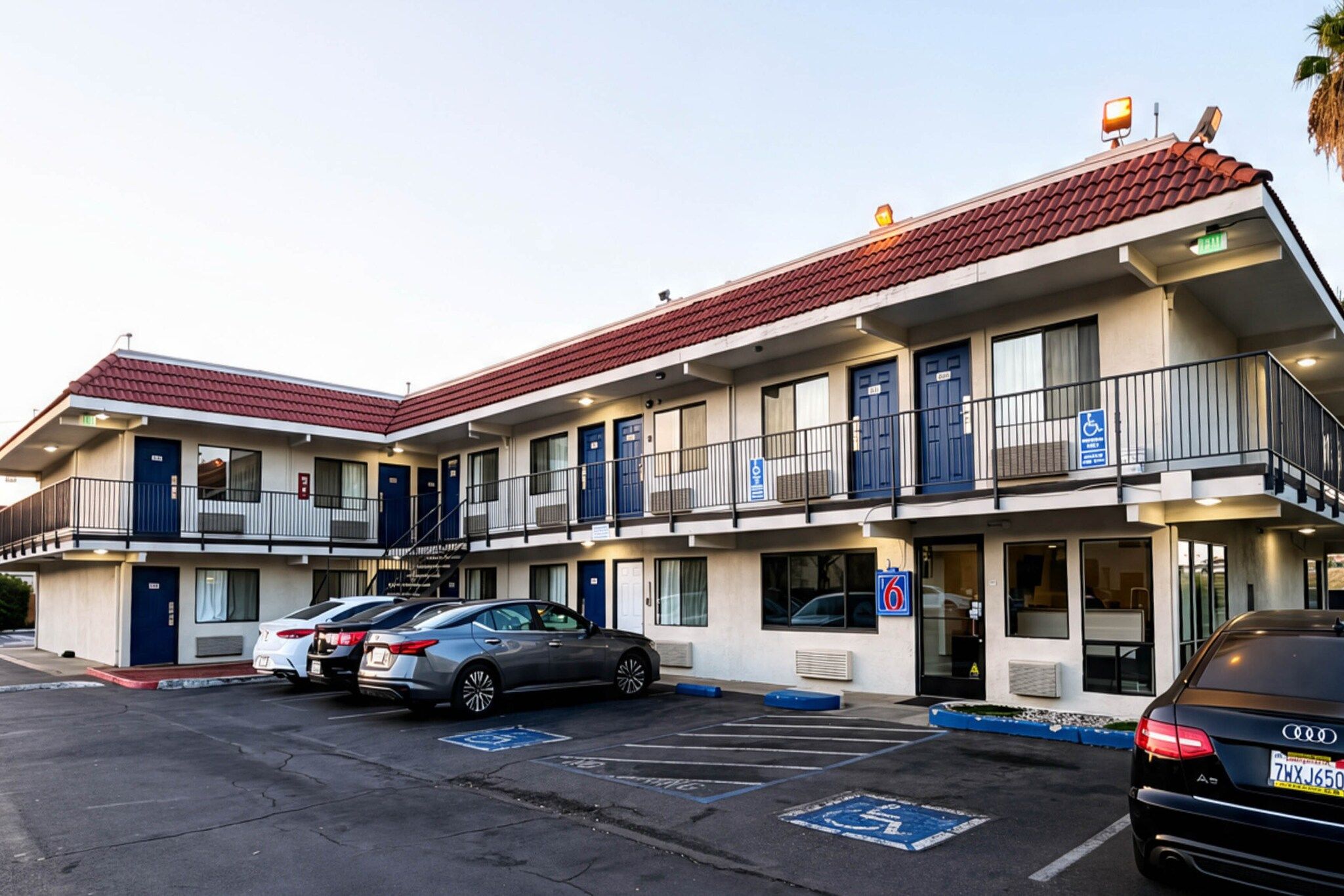 A motel with multiple rooms, a parking lot, and a handicap-accessible parking space.