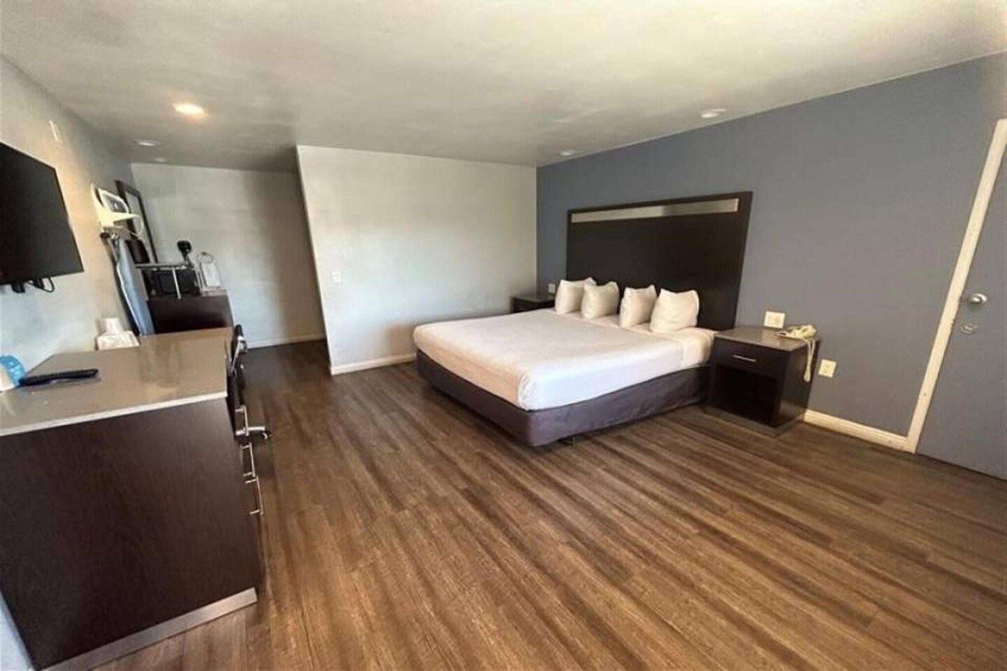 Een moderne hotelkamer met een groot bed, een bureau en een flatscreen televisie.