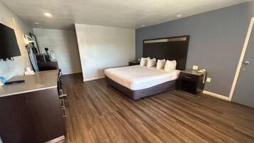 Een moderne hotelkamer met een groot bed, een bureau en een flatscreen televisie.