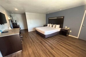 Een moderne hotelkamer met een groot bed, een bureau en een flatscreen televisie.