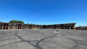 A large parking lot with a multi-story building in the background.