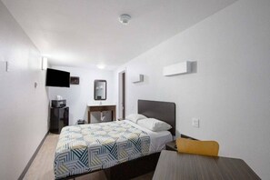 A hotel room with a bed, a desk, a chair, a TV, and a mirror. - 1 Queen Bed | Non-Smoking, Micfridge (Show Low)