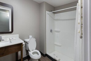 Une salle de bain avec des toilettes, un lavabo et une douche.