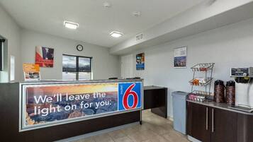 A reception area with a counter, a clock, and a window.
