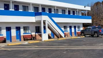 A motel with a central staircase, multiple rooms, and a parking lot.