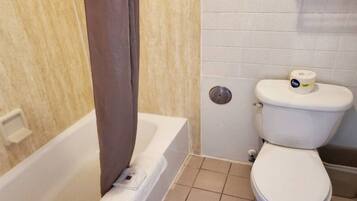 A bathroom with a bathtub, toilet, and a shower curtain.
