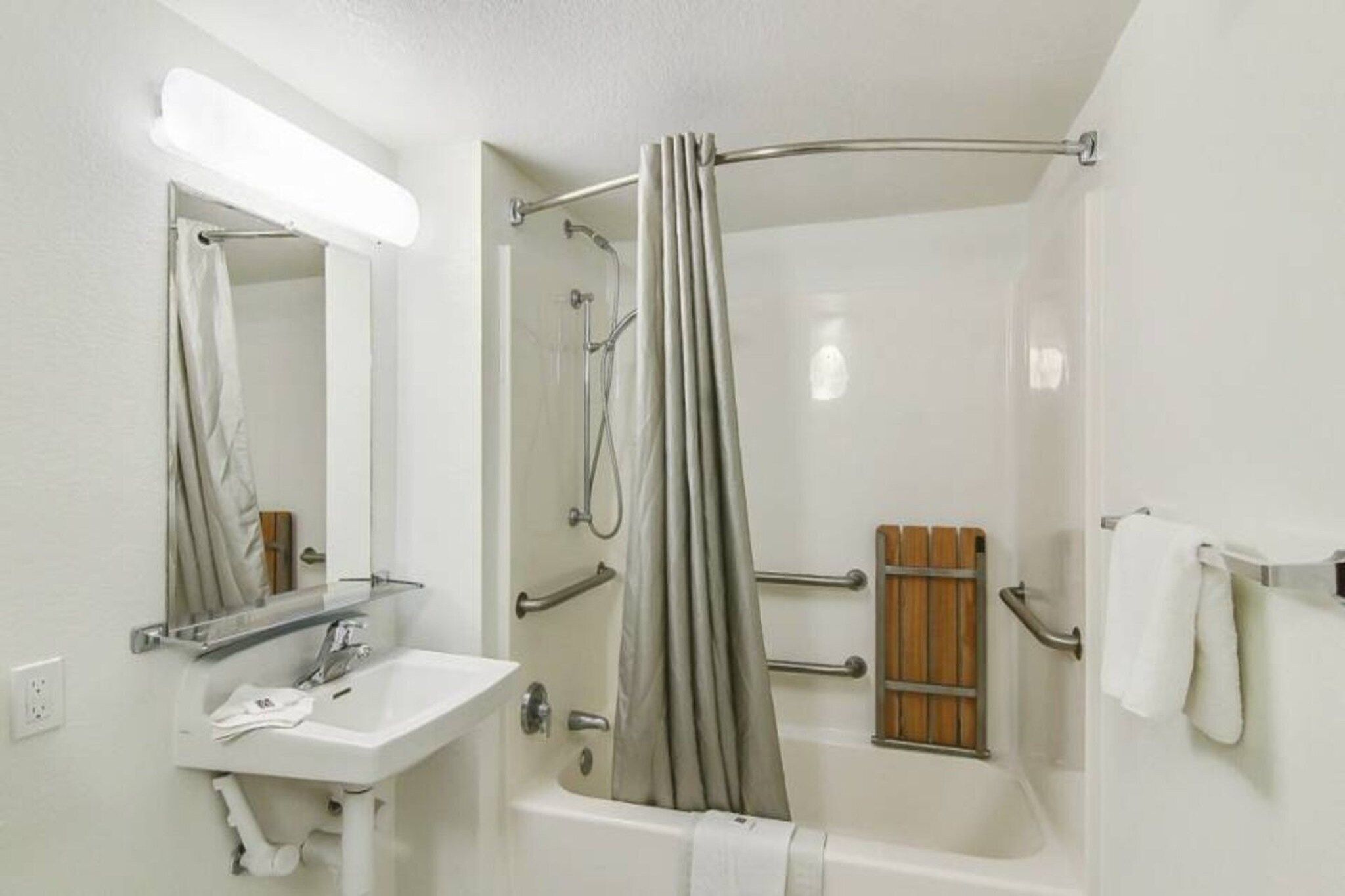 A bathroom with a bathtub, a shower, a sink, and a mirror.