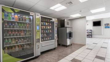A vending machine area with a beverage dispenser and a refrigerated unit.