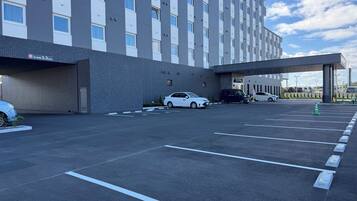 Un parking avec un immeuble à plusieurs étages en arrière-plan.