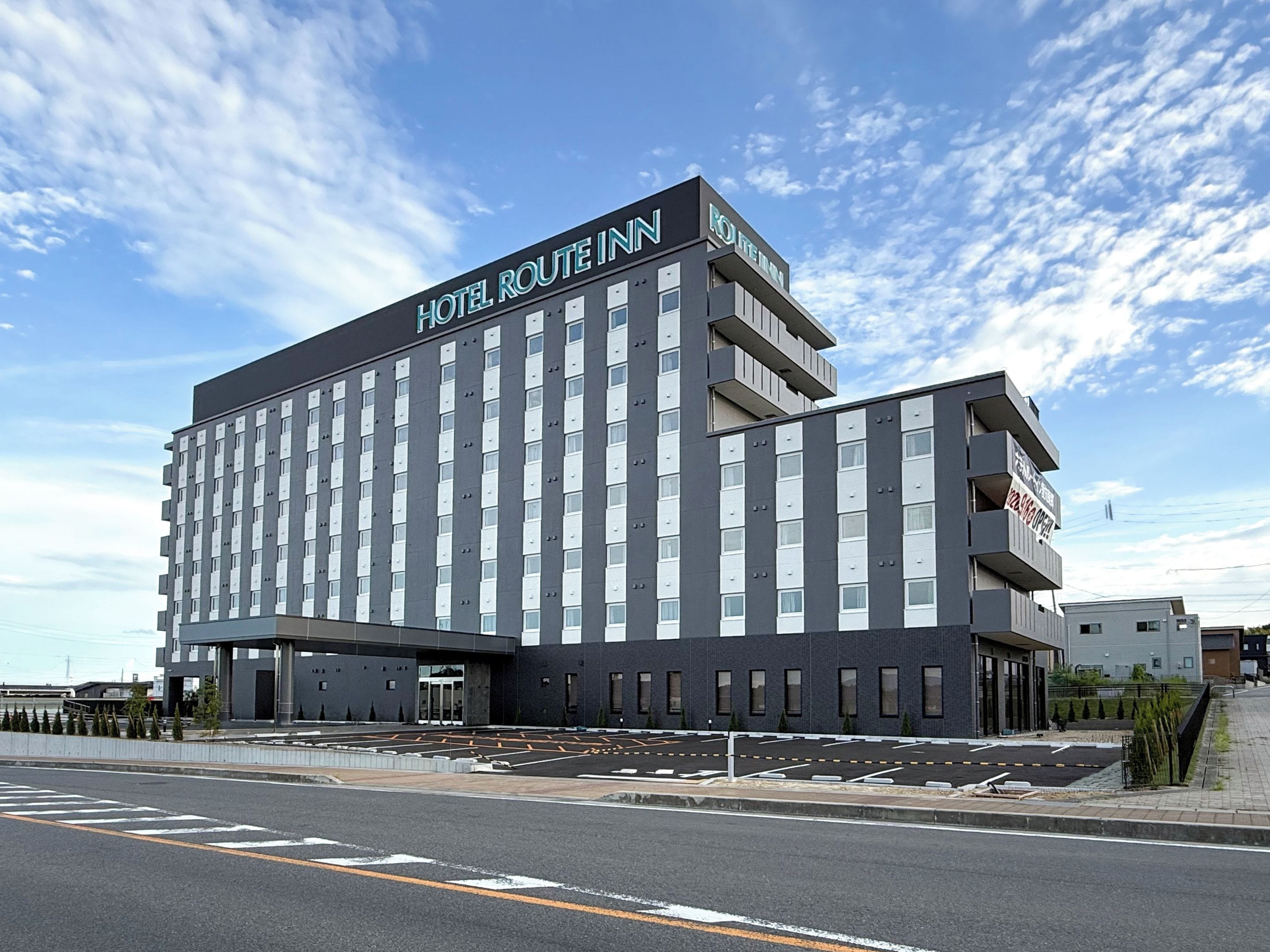A modern hotel building with a prominent sign reading 'HOTEL ROUTE INN.'