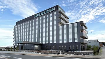 A modern hotel building with a prominent sign reading 'HOTEL ROUTE INN.'