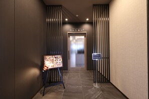 Un pasillo con letrero de restaurante, un menú y una puerta hacia el ascensor.