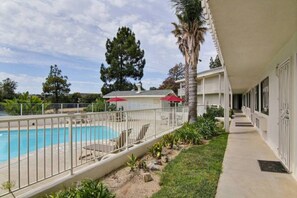 Un hotel con piscina, un patio cubierto y vistas del paisaje circundante.