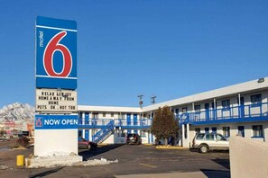 A motel with a large sign indicating it is now open, featuring a number 6 and a pet-friendly message. - 2 Queen Beds | Non-Smoking, Micfridge (Cañon City)