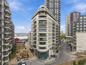 A high-rise residential building with multiple balconies, a curved facade, and a central glass entrance. - 2 Bed 2 Bath Willesden Junction New furniture (Greater London)