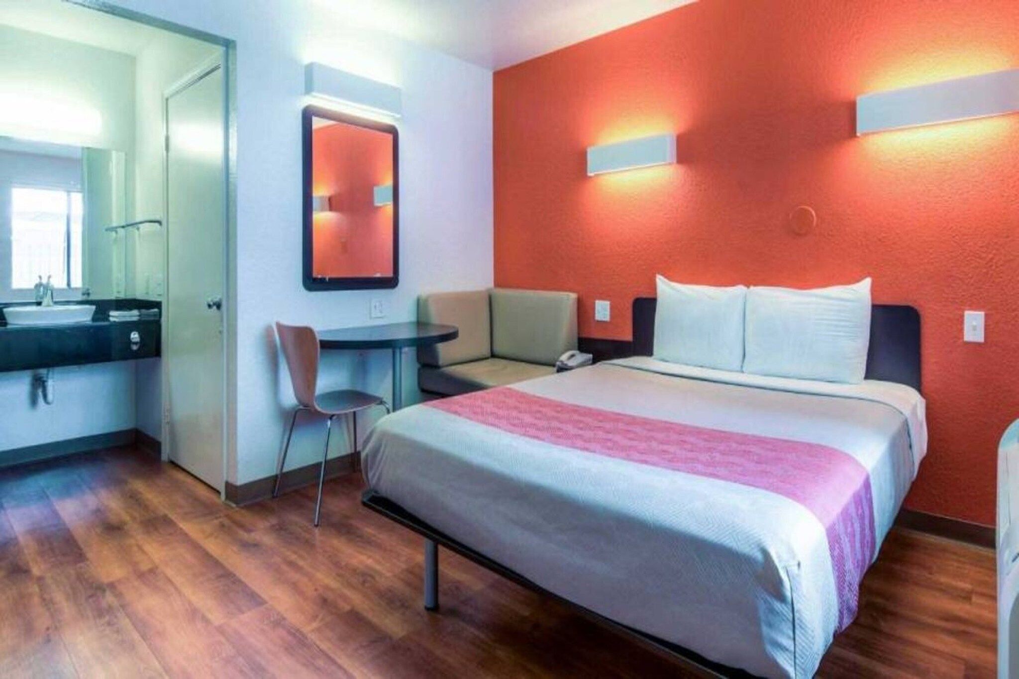 Ein Hotelzimmer mit Bett, Schreibtisch, Stuhl und Bad.