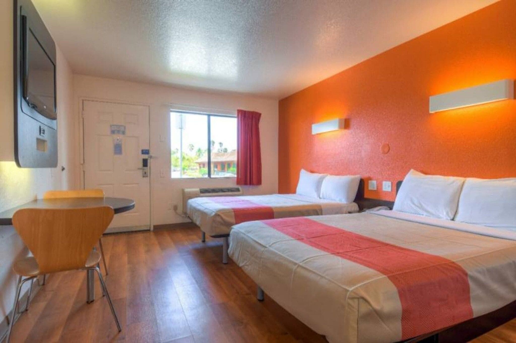 Ein Hotelzimmer mit zwei Betten, einem Schreibtisch und einem Sessel.