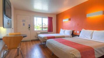 Ein Hotelzimmer mit zwei Betten, einem Schreibtisch und einem Sessel.