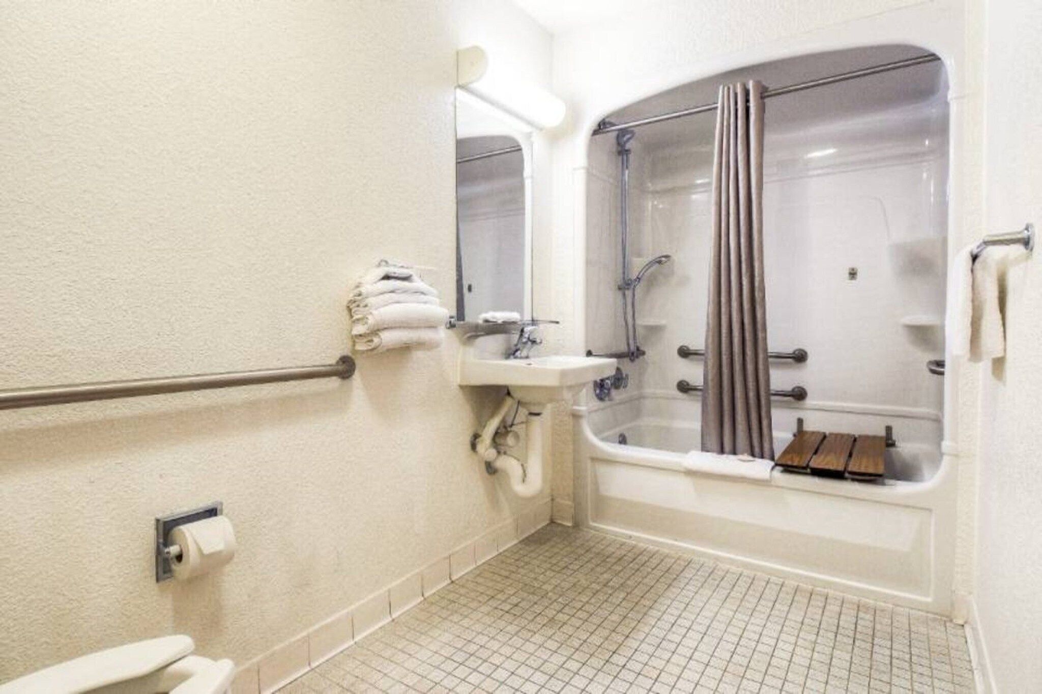 Un baño de hotel estándar con ducha, lavamanos e inodoro.