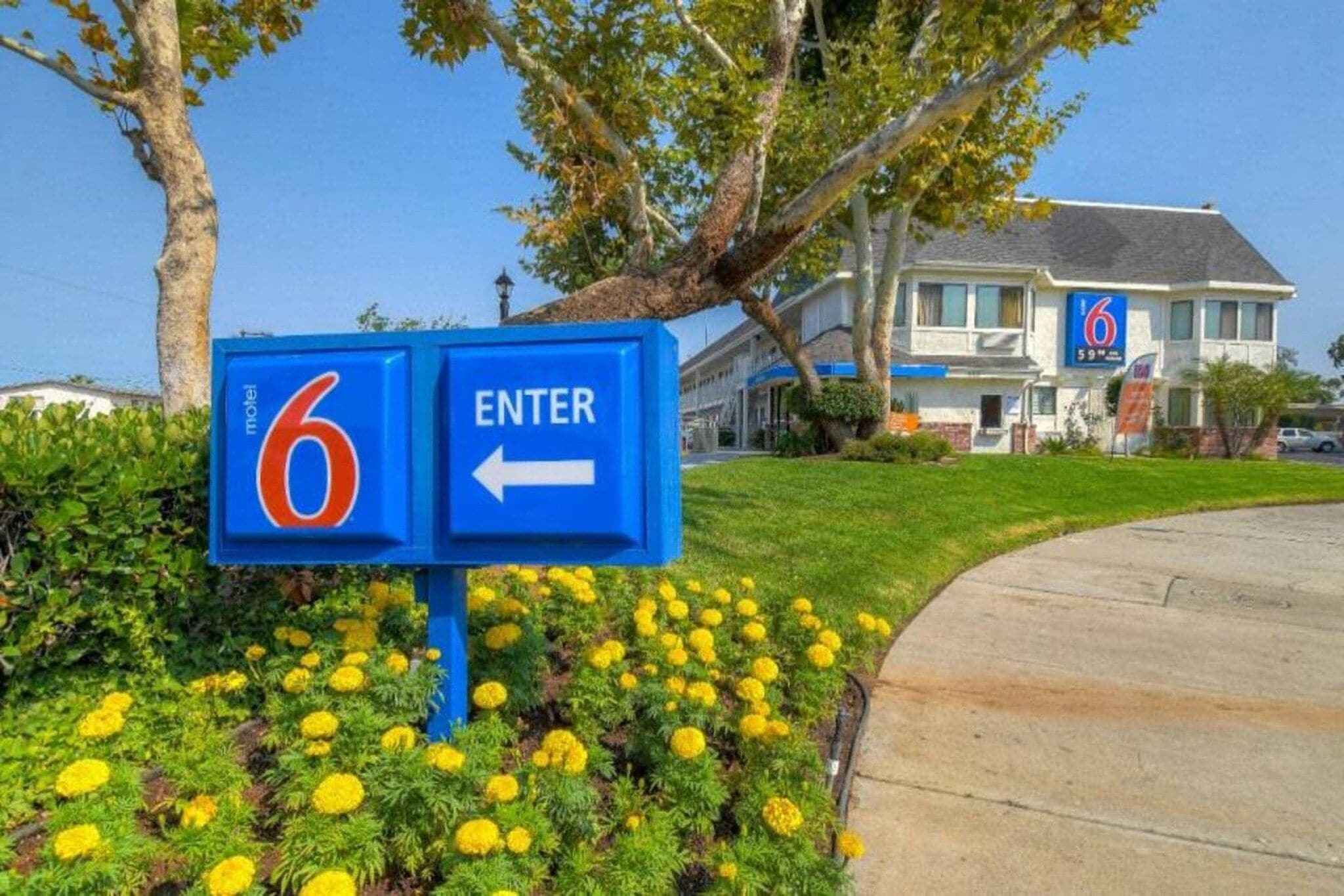 Une enseigne de motel avec une flèche pointant vers la gauche, indiquant la direction à suivre pour entrer.