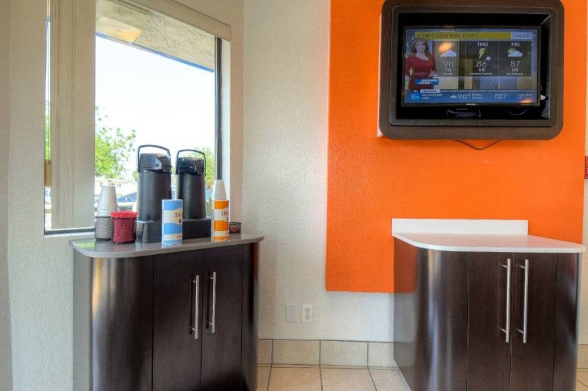 Une petite cuisine équipée d’une machine à café, d’un distributeur d’eau et d’un petit réfrigérateur.