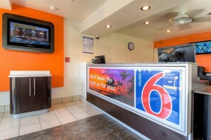 A hotel reception area with a digital screen displaying a weather forecast, a large number '6' sign, and a 'We'll leave the light on for you' sign. - Cozy ADA QueenBed|Pool|Free Parking (El Cajon)