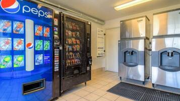 Un espace équipé de distributeurs automatiques, comprenant un réfrigérateur à boissons Pepsi et deux distributeurs d’eau.