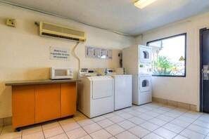 Une buanderie équipée d’un four à micro-ondes, de machines à laver et d’un sèche-linge.