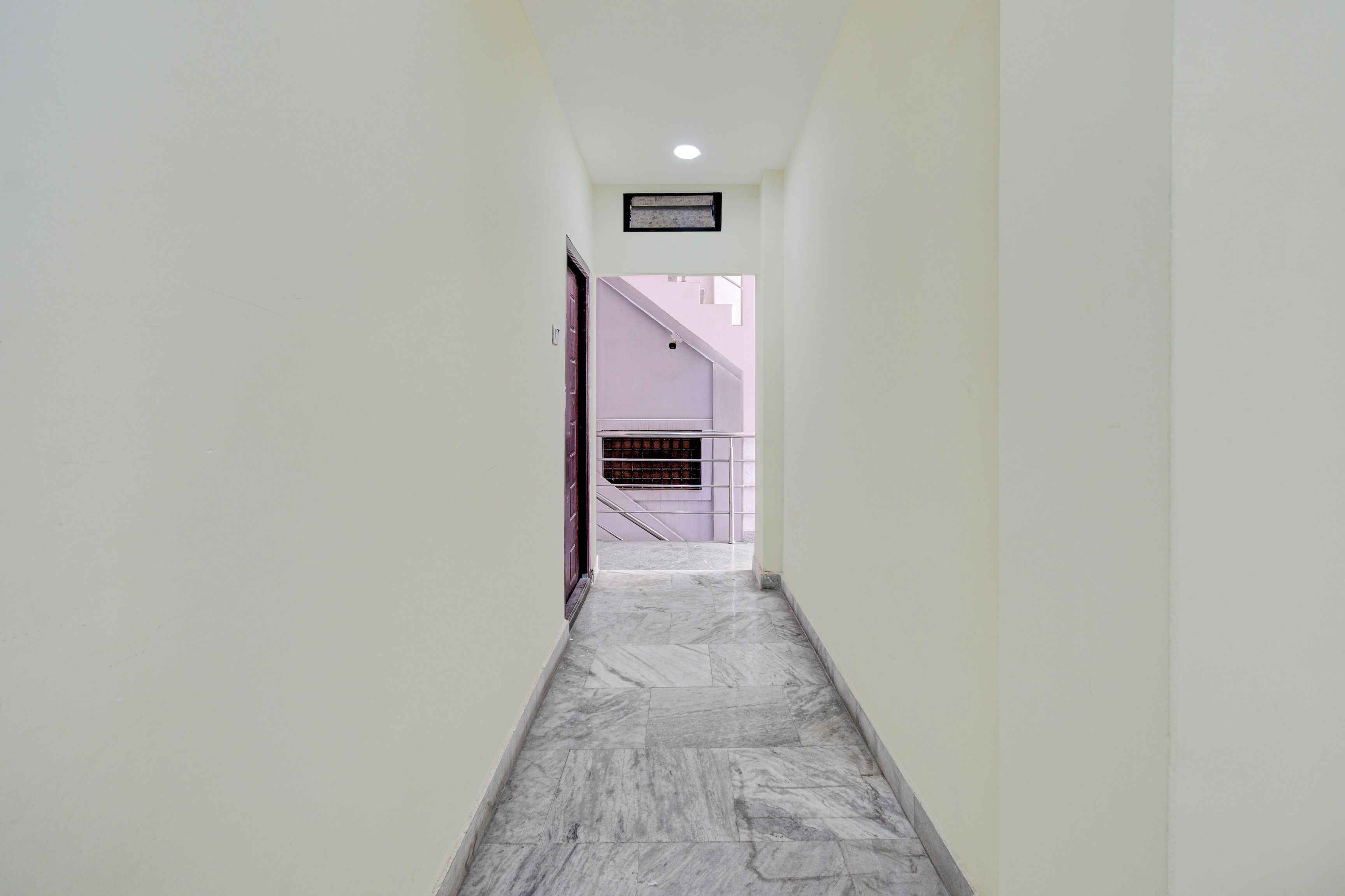 Un pasillo con piso de mármol que conduce a una escalera.