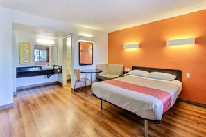 A hotel room with a bed, a desk, a chair, a bathroom, and a mirror. - Spacious 1  Queen Bed|Free Parking (Campbell)