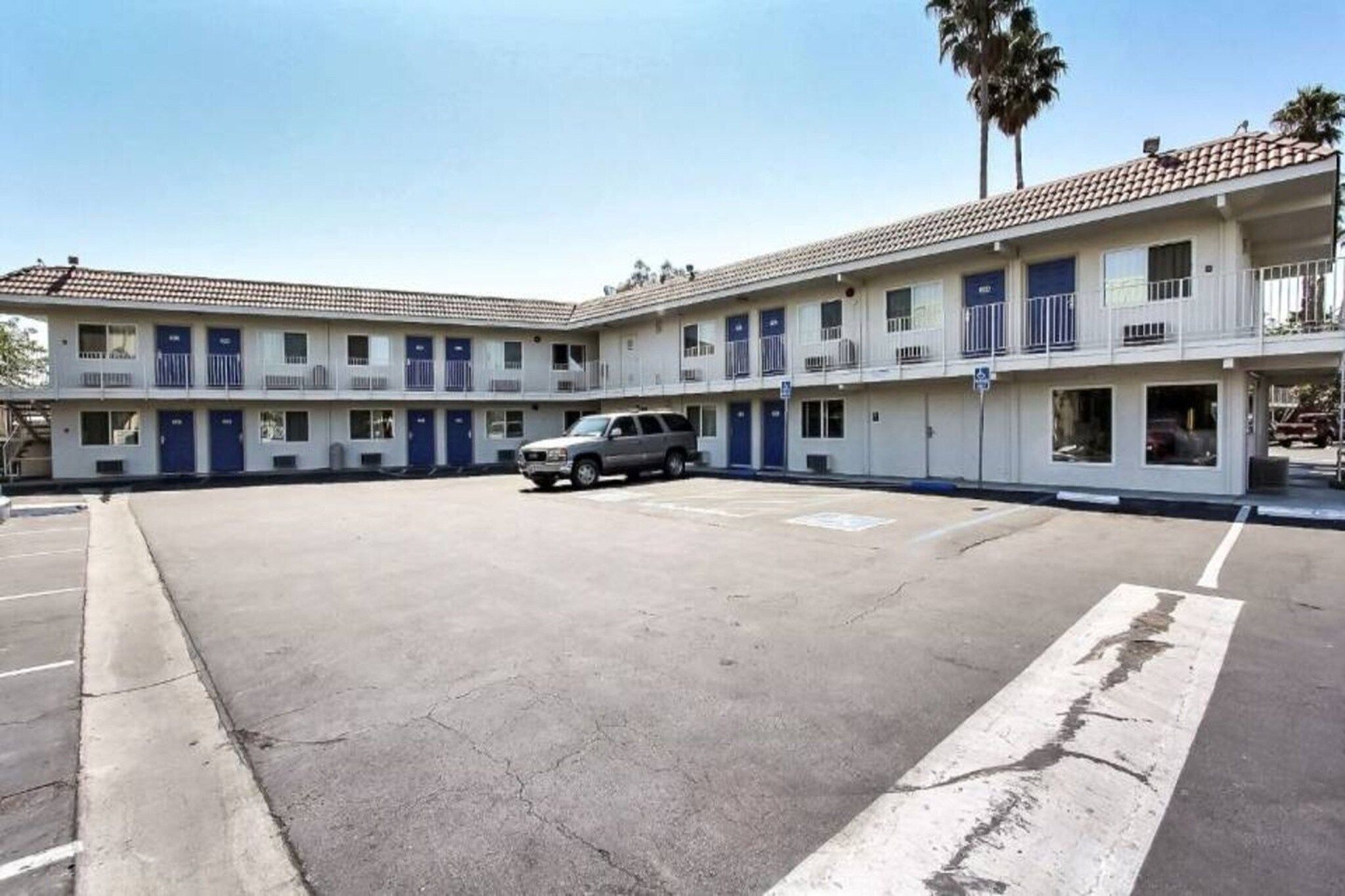 A two-story motel with a parking lot in front.