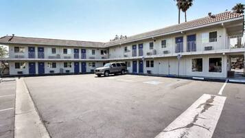 A two-story motel with a parking lot in front.