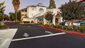 A hotel with a parking lot, marked lanes, and a fire lane.